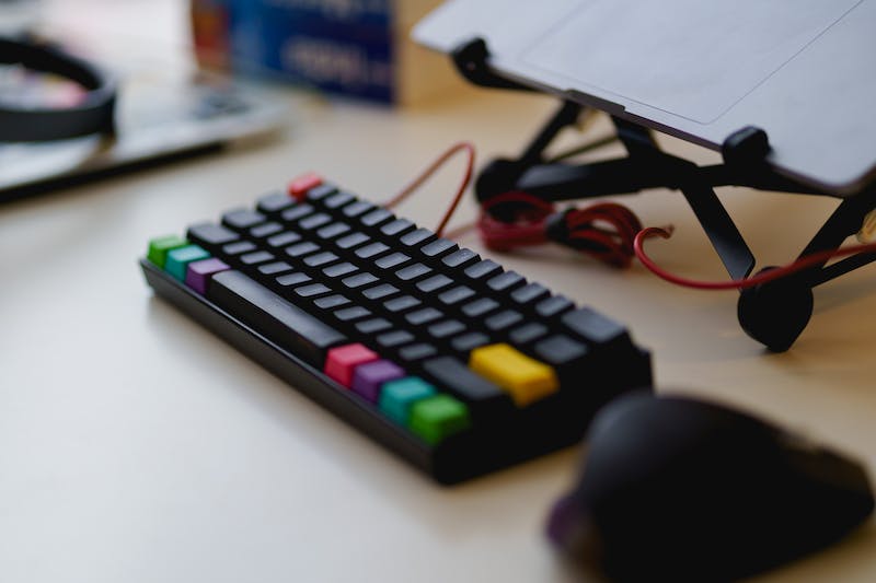 Clavier noir avec souris sans fil bluetooth sur un bureau debout avec un ordinateur portable sur un support d'ordinateur portable.