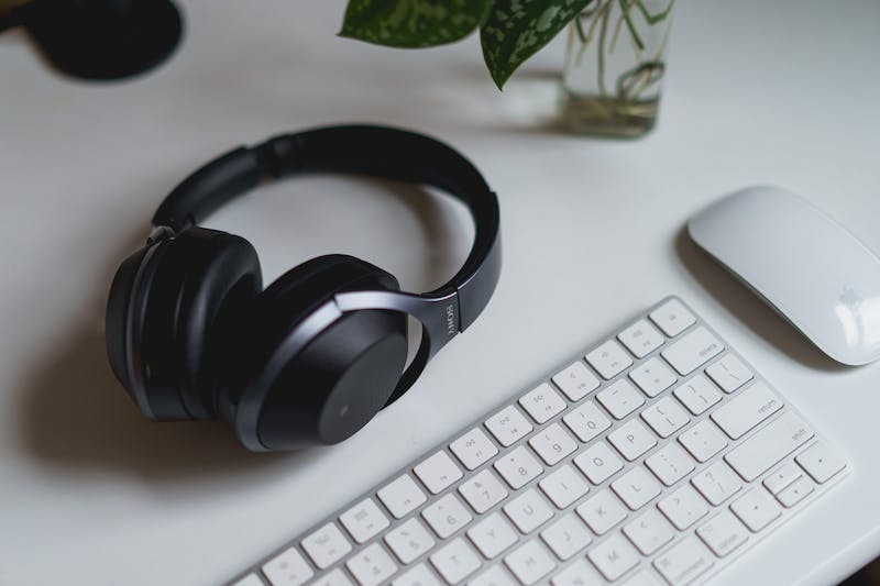 Utilisation d'un casque bluetooth Sony dans un bureau à domicile avec un clavier et une souris sans fil apple magic keyboard et apple wireless mouse.