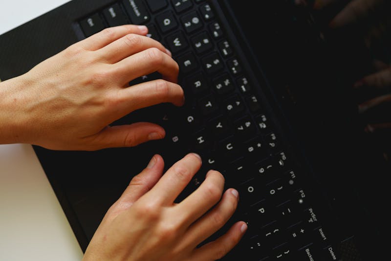 Femme tapant sur le clavier d'un ordinateur portable Dell XPS de petite taille alors qu'elle travaille depuis son domicile dans un bureau à domicile.