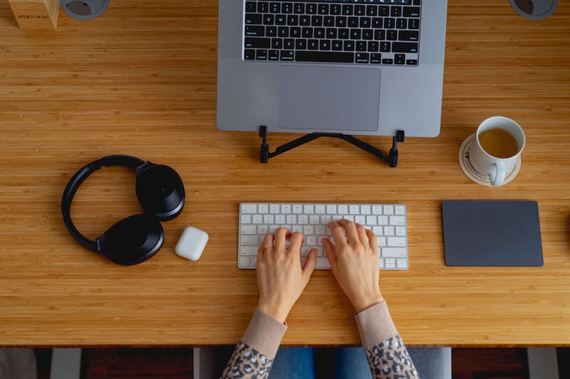 Les mains d'une femme tapant sur un clavier à un bureau.