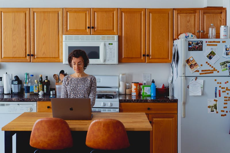 Femme travaillant avec un ordinateur portable dans une cuisine