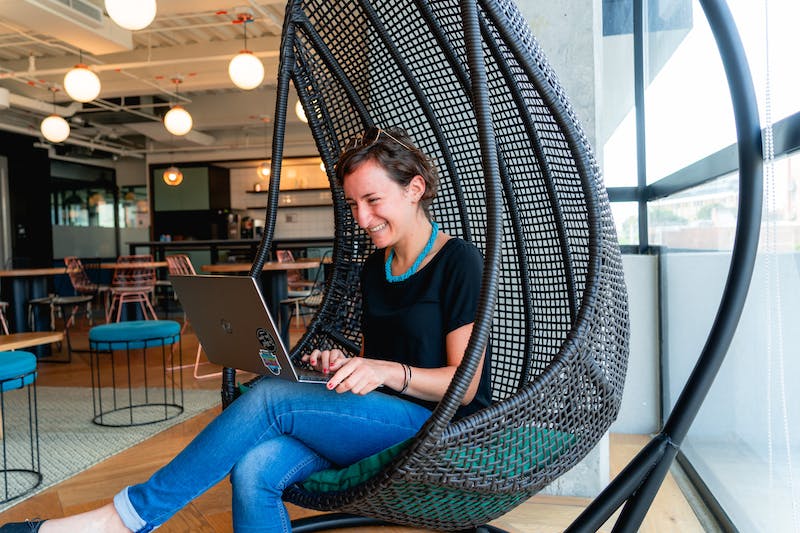 Femme travaillant sur une chaise suspendue dans un espace de coworking