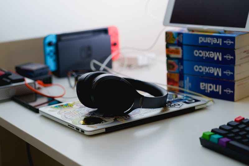 Casque bluetooth Sony à réduction de bruit posé sur un MacBook fermé sur un bureau debout dans un bureau à domicile.