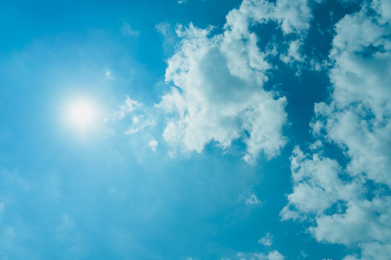 Soleil et nuages blancs gonflés dans un ciel bleu clair
