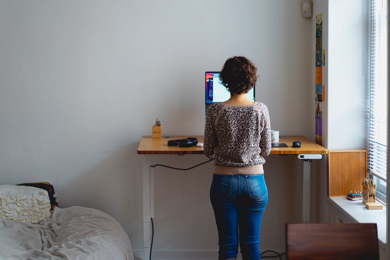 Une femme travaillant à un bureau dans sa chambre.