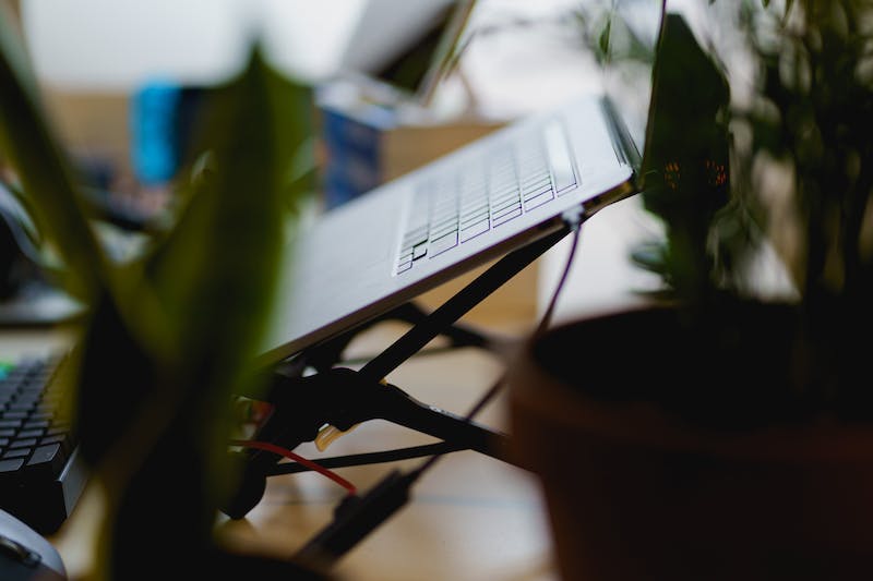 MacBook Pro utilisé sur le support d'ordinateur portable Roost dans un bureau à domicile avec plantes.