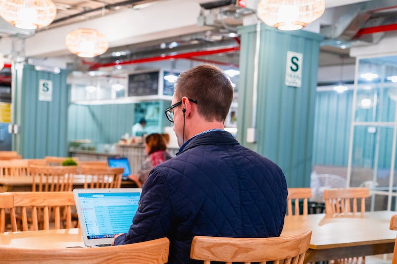 Un homme assis à une table avec un ordinateur portable.