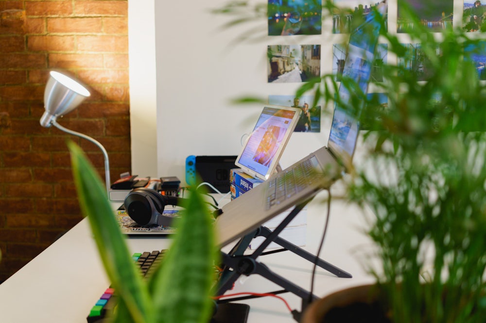 Installation d'un bureau à domicile sur un bureau debout avec un clavier externe, un ordinateur portable sur un support pour ordinateur portable et un ipad comme moniteur externe.