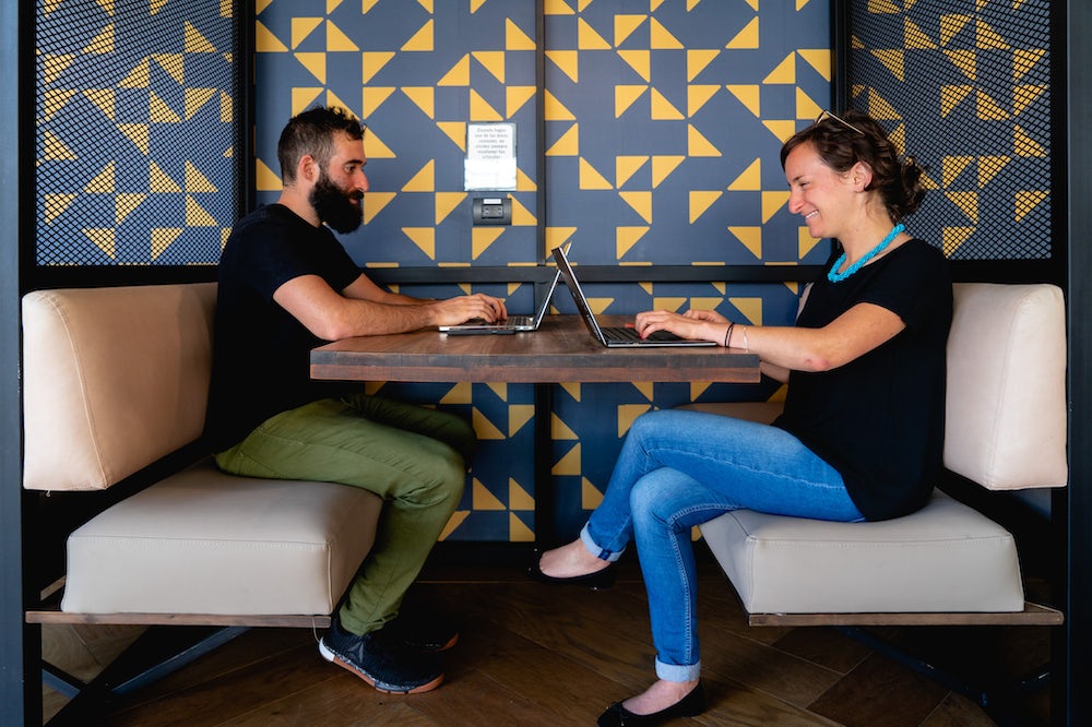 Homme et femmes travaillant à un bureau partagé dans un espace de coworking à Medellin
