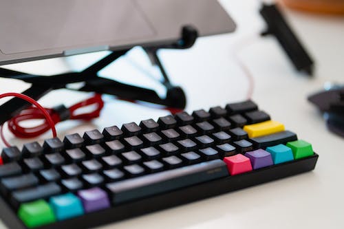 Clavier mécanique externe avec touches multicolores arc-en-ciel sur un bureau à domicile